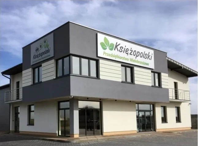 Budynek handlowy Księżopolski z zielonym szyldem.