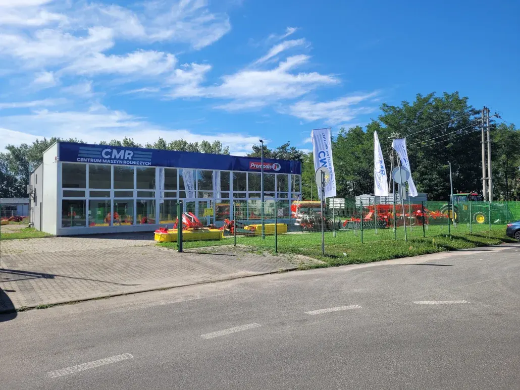 Budynek i ekspozycja maszyn Centrum Maszyn Rolniczych przy parkingu.