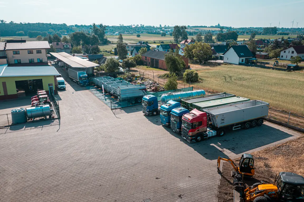 Ciągniki i maszyny ustawione obok hal Toral widziane z góry.