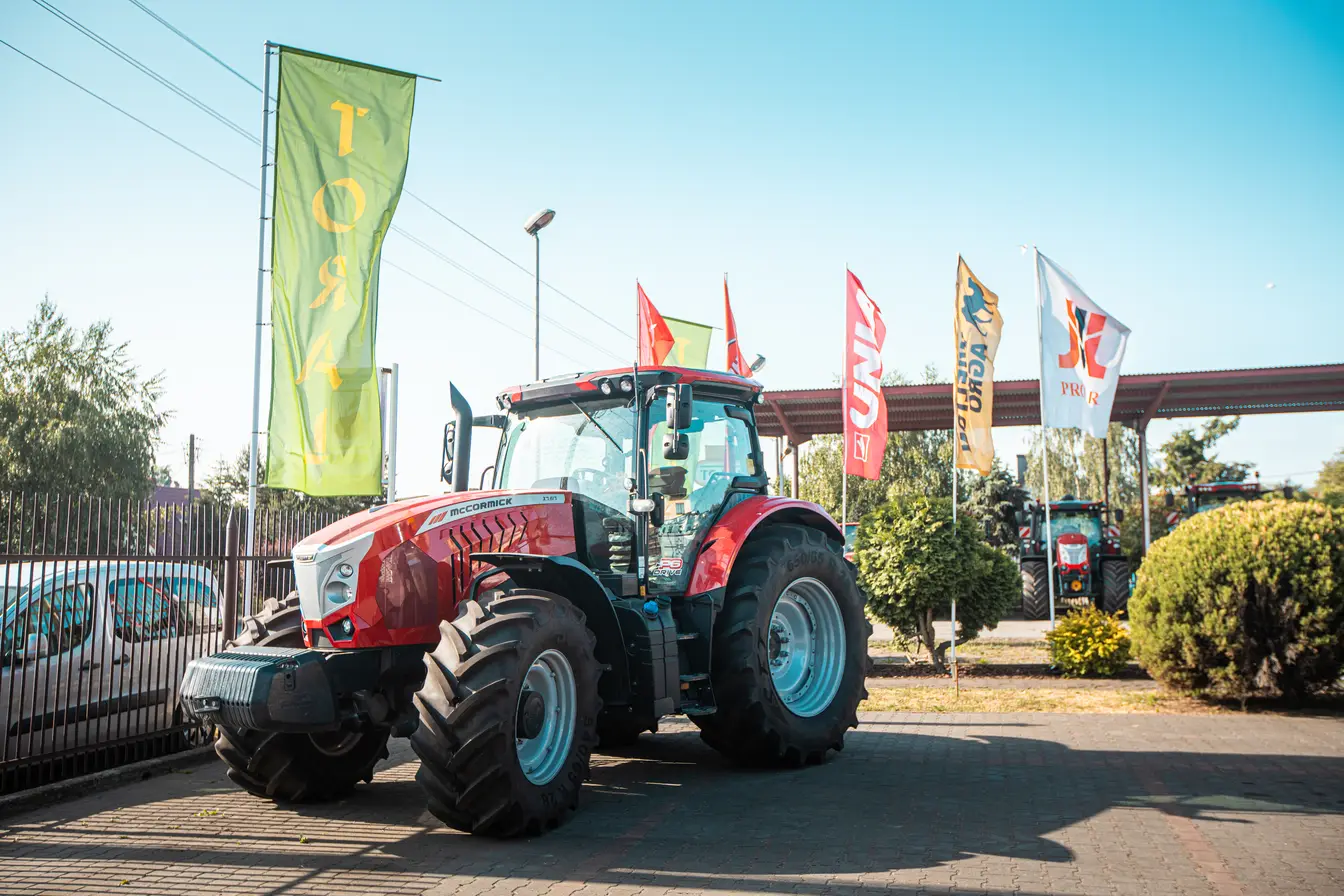 Czerwony ciągnik rolniczy i flagi przed siedzibą Toral.