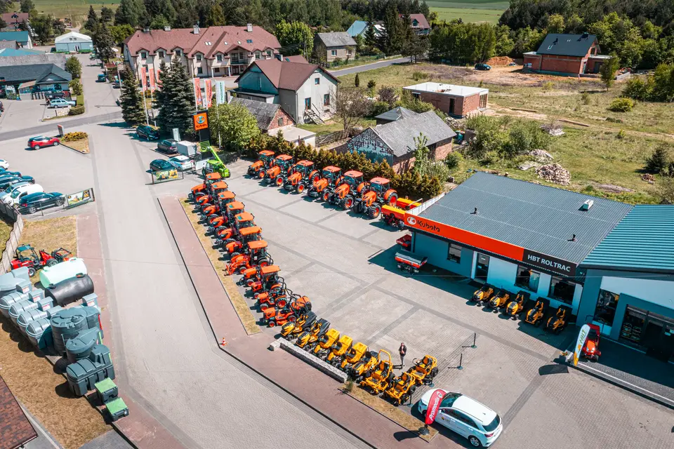 Rząd ładowarek i budynki HBT Roltrac widziane z góry.