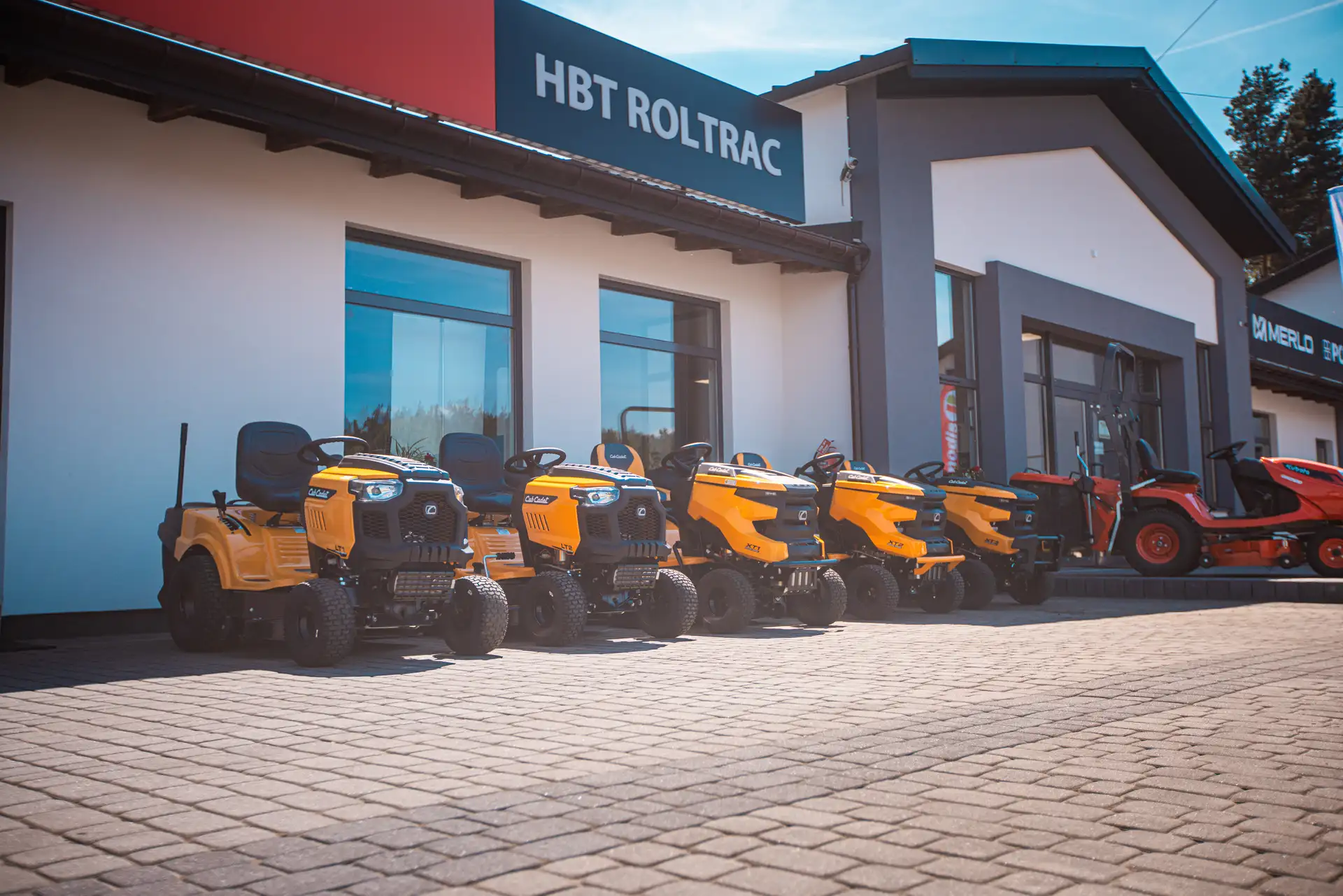 Żółte maszyny przed wejściem do hali HBT Roltrac.