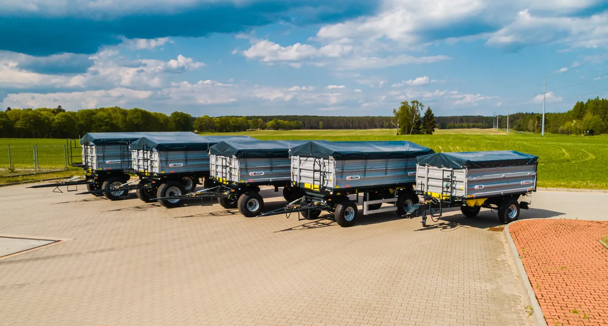 Przyczepy Cargo Szereg niezawodnych przyczep objętościowych Cargo z plandekami zaparkowanych na placu dealera maszyn rolniczych Promodis.
